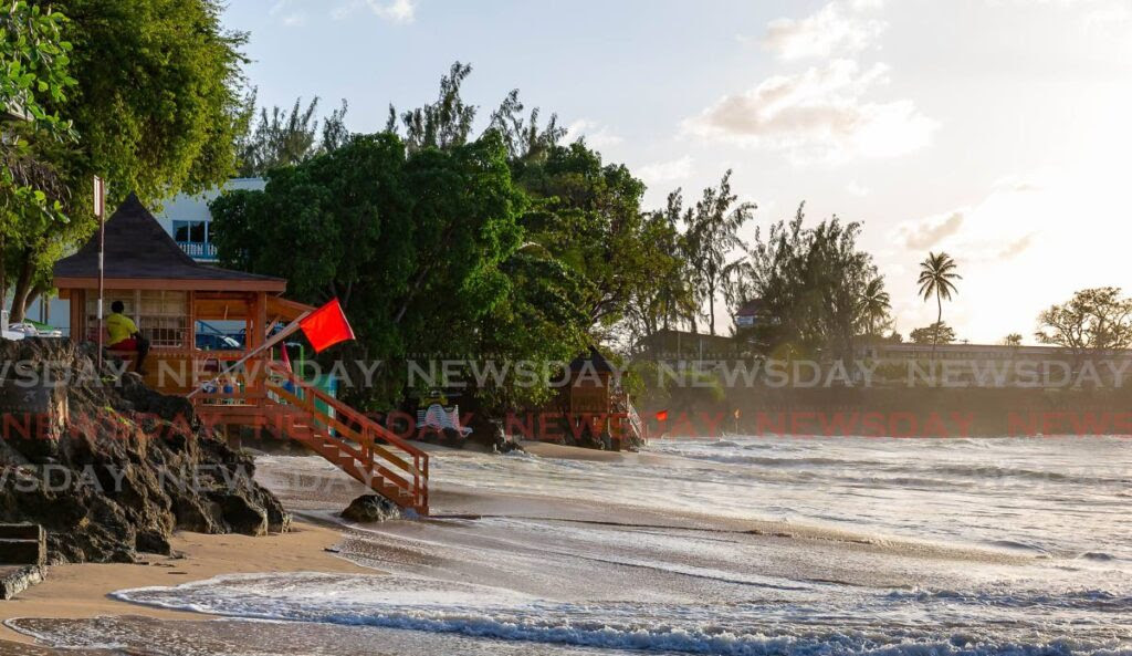 Red flags at the lifeguard booths at Store Bay on Friday, warning the public not to bathe in the water. Photo by David Reid