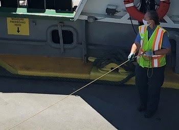 Photo of crewmember wearing a mask while working aboard a ferry