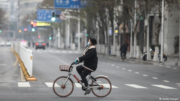 Mulher de máscara pedala em Wuhan