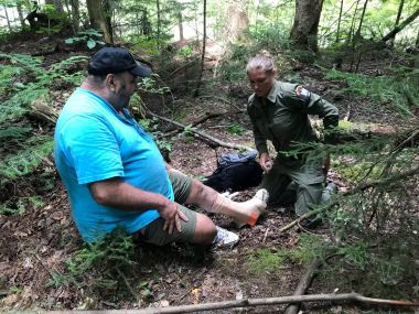Ranger tends to injured hiker's ankle on the hiking trail
