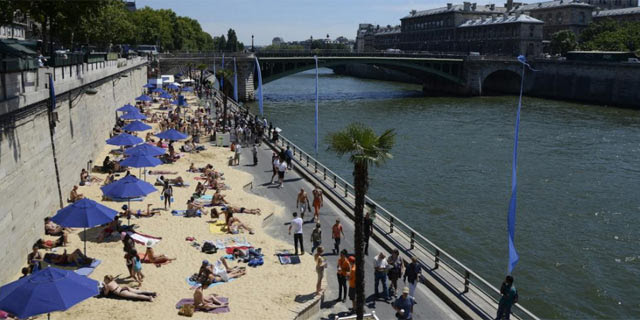 Bañistas tomando el sol a las orillas del río Sena, en París. | Efe