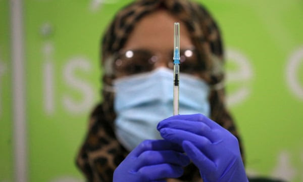 A health worker prepares a coronavirus vaccine at a pop-up Covid-19 vaccination clinic operating at the MyLahore British Asian Kitchen in Bradford, West Yorkshire on 23 December 2021.