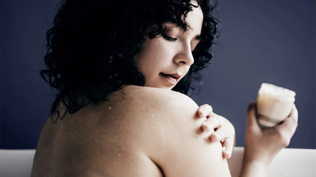 A woman in the bath using an eczema skin care product.