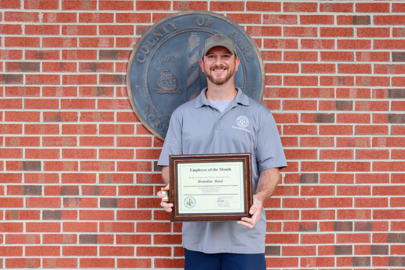Image of Brandon Reed holding his Employee of the Month certificate.