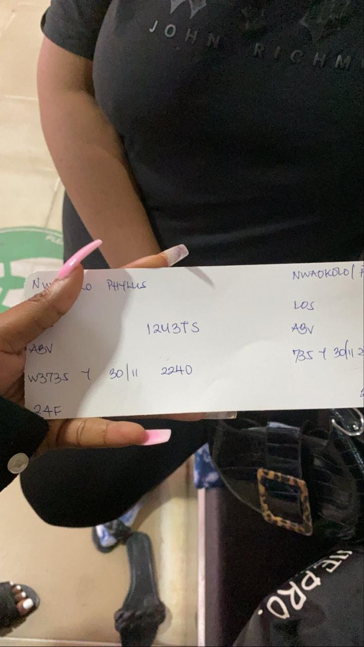 Nigerian lady shows off the boarding pass she got at an airport 