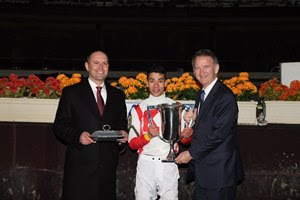 (L-R): Chad Brown and Jose Ortiz accept the Cigar Mile trophy from Chris Kay of the New York Racing Association