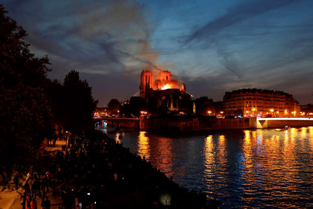 Slide 9 of 31: Firefighter douse flames billowing from the roof at Notre-Dame Cathedral in Paris on April 15, 2019. - A fire broke out at the landmark Notre-Dame Cathedral in central Paris, potentially involving renovation works being carried out at the site, the fire service said. (Photo by Thomas SAMSON / AFP) (Photo credit should read THOMAS SAMSON/AFP/Getty Images)