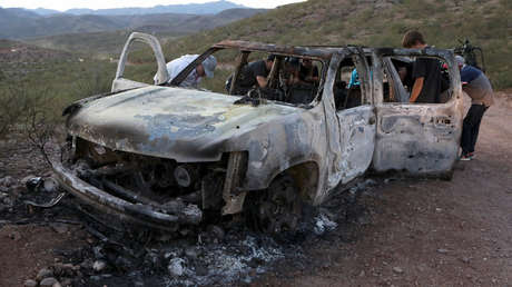 Miembros de la familia LeBarón miran el auto quemado donde viajaban sus familiares asesinados en Bavispe, Sonora, México, el 5 de noviembre de 2019.