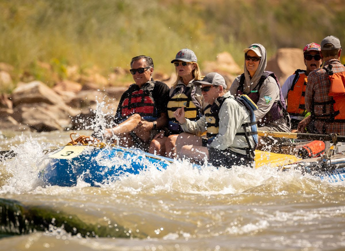 Sen. Mitt Romney, R-Utah, left, his wife, Ann, and Sen. Michael Bennet, D-Colo., sit together in a raft while they float a section of the Colorado River northeast of Moab on Saturday, Sept. 18, 2021.