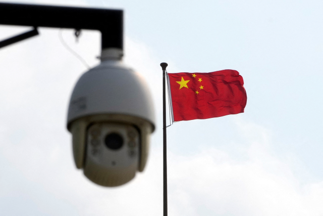 A surveillance camera is seen near a Chinese flag in Shanghai, China