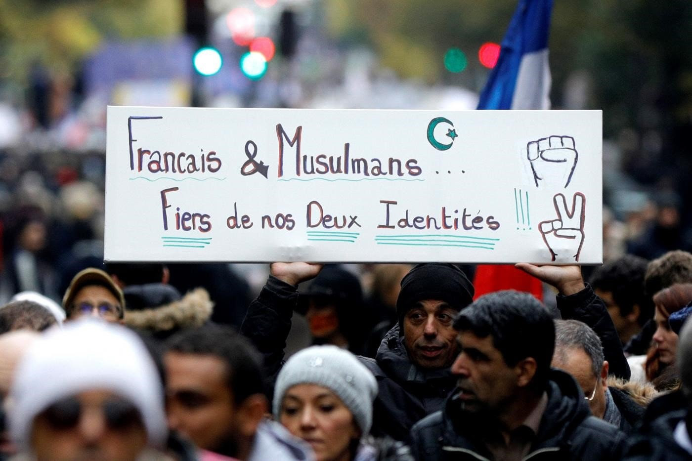 Un manifestant brandit une pancarte indiquant « Français et musulmans… Fiers de nos deux identités ! » au cours d’une manifestation contre l’islamophobie, le 10 novembre 2019 à Paris (AFP)