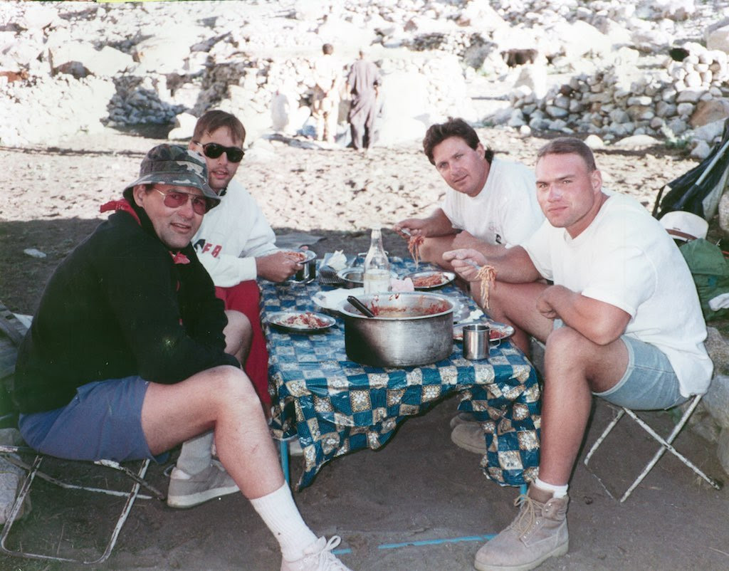 Ed, Erik, Mark, and Eddi Weihenmayer camping and eating together on a trek in Pakistan