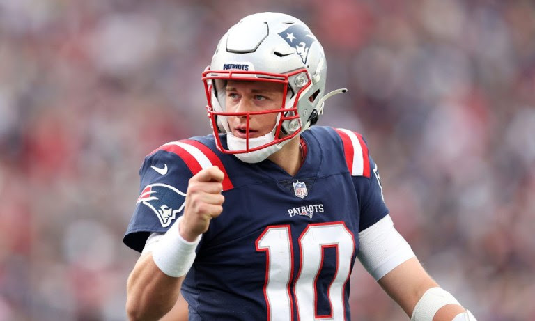 Mac Jones (#10) pumps his fist for the Patriots in 2021 matchup