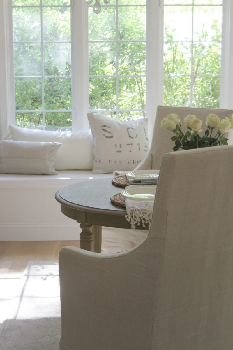 Belgian linen chairs and window seat in calm white kitchen by Hello Lovely Studio