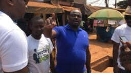 Armand Okol, candidat députe en bleu fait le porte à porte dans l’arrondissement de Yaoundé, le 1er février 2020. (VOA/Emmanuel Jules Ntap)