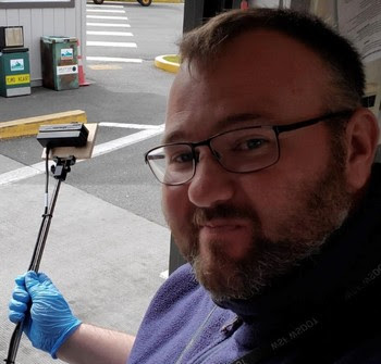 Photo of terminal employee using a selfie stick with credit card reader attached