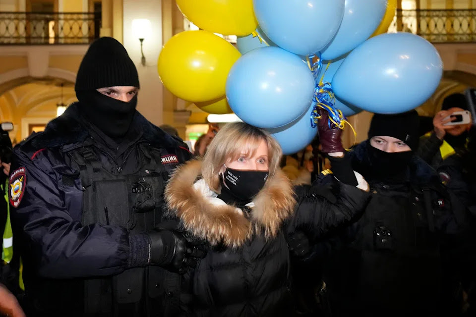 CAPTION CORRECTS DATE Police officer detain a woman during an action against Russia's attack on Ukraine in St. Petersburg, Russia, Thursday, Feb. 24, 2022. Hundreds of people gathered in the center of Moscow on Thursday, protesting against Russia's attack on Ukraine. Many of the demonstrators were detained. Similar protests took place in other Russian cities, and activists were also arrested. (AP Photo/Dmitri Lovetsky)