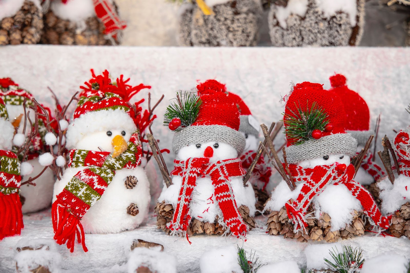 A group of snowmen with hats and scarvesDescription automatically generated