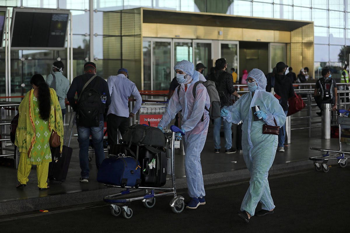 click for large image Passengers wearing personal protective equipment (PPE) enter Chhatrapati Shivaji International Airport, after the government allowed domestic flight services to resume, during an extended nationwide lockdown to slow the spread of the coronavirus disease (COVID-19), in Mumbai, India, on 25 May 2020.