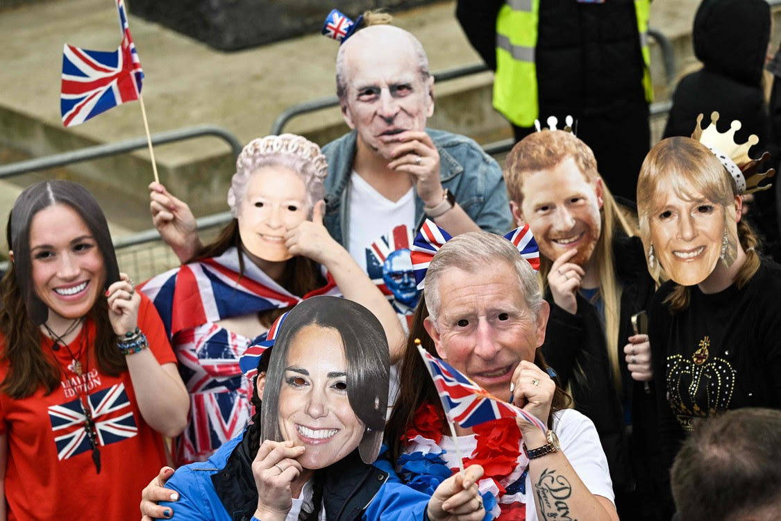 Những người ủng hộ đeo mặt nạ của các thành viên Hoàng gia chờ đợi dọc theo tuyến đường của 'Đám rước của nhà vua'.  (Ảnh LOIC VENANCE/AFP)