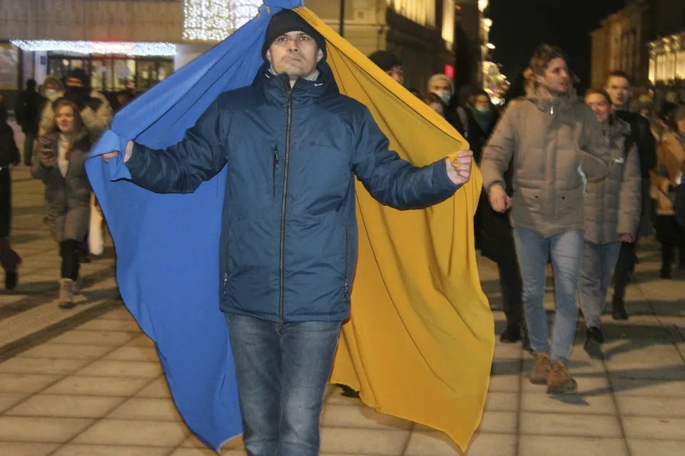 A protester with a Ukrainian flag walks in Nizhny Novgorod, Russia, Thursday, Feb. 24, 2022. Hundreds of people gathered in the center of Moscow, St. Petersburg, Nizhny Novgorod and other Russian cities on Thursday, protesting against Russia's attack on Ukraine. Many of the demonstrators were detained. Similar protests took place in other Russian cities, and activists were also arrested. (AP Photo/Dmitri Lovetsky)