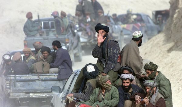 A column of Taliban fighters go through the front line in the village of Amirabad, northern Afghanistan, Saturday Nov. 24 2001. Hundreds of Taliban defected to the northern alliance Saturday, paving the way for the fall of Kunduz where several thousand foreign fighters are said to remain. (AP Photo/Dusan Vranic)