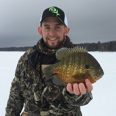 ice angler holding a sunfish