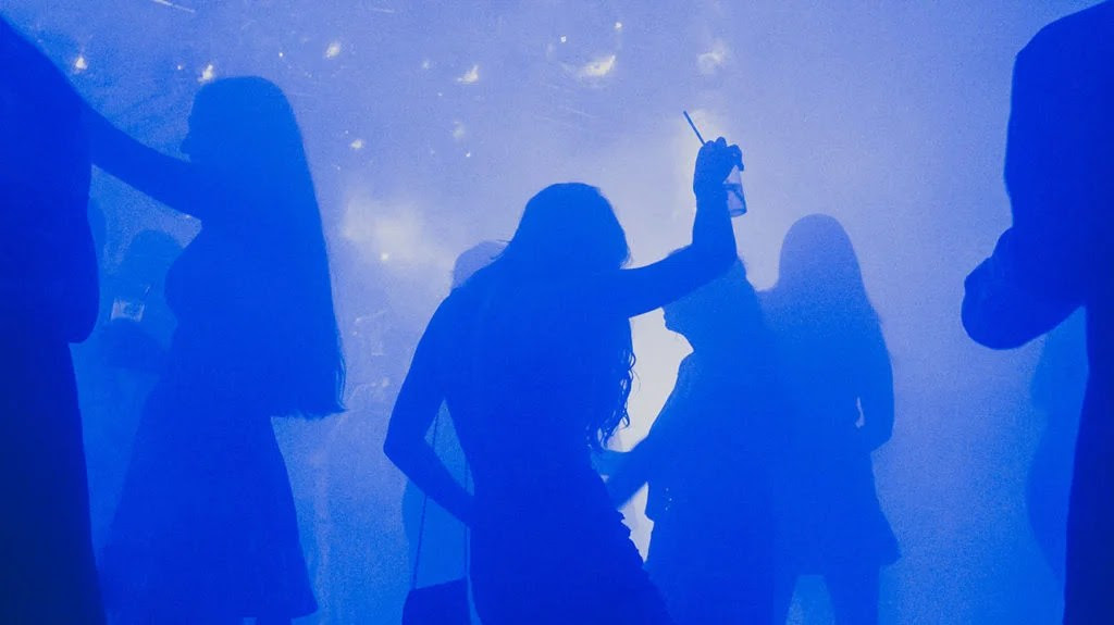 A woman in silhouette dances with a glass of alcohol, which can be lethal when combined with cocaine.