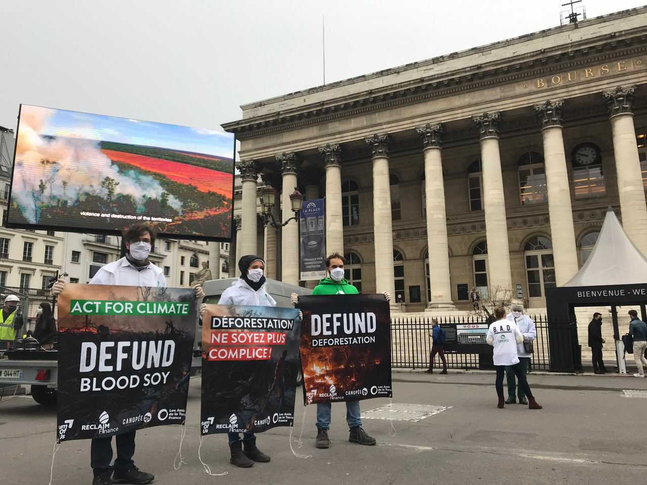 Activists from Reclaim Finance, Canopée and Friends of the Earth in front of the entrance of the Climate Finance Day event 