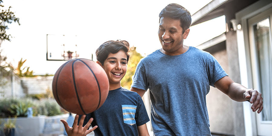 foto de un padre e un hijo jugando con una pelota de baloncesto