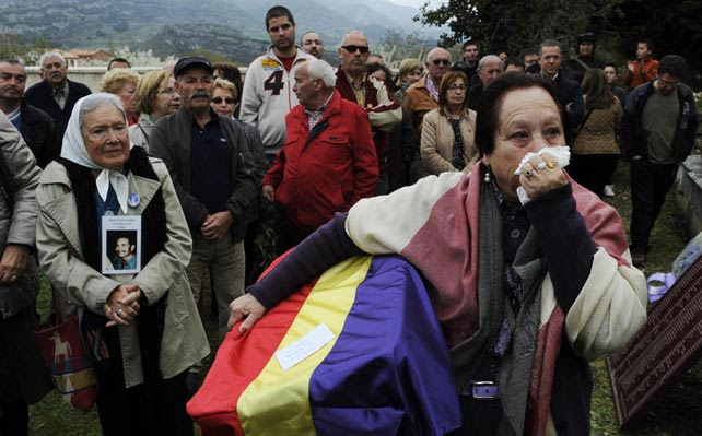 Juana Gutiérrez llora mientras mantiene los restos de su abuelo, víctima de la Guerra Civil, en el cementerio de Valdenoceda, cerca de Burgos.