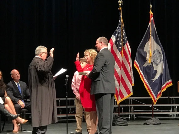 State Superintendent Jillian Balow holds up her right hand with her left hand on a bible held by her husband to take the Oath of Office from the Chief Justice of the Wyoming Supreme Court during the Swearing-In Ceremony at the Cheyenne Civic Center.
