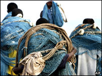 Fishermen carry their nets in Ghana