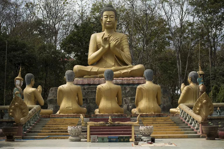 Statue of buddha with followers in Cambodian temple.