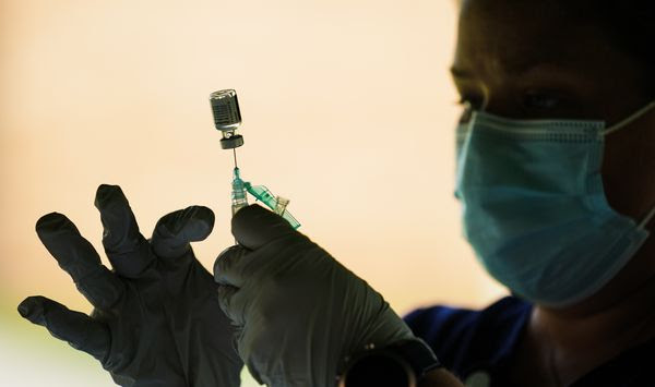 In this Sept. 14, 2021, file photo, a syringe is prepared with the Pfizer COVID-19 vaccine at a clinic at the Reading Area Community College in Reading, Pa. Companies with at least 100 workers will be required to give employees paid time off to get vaccinated against COVID-19 and paid sick leave if they have side effects from the shots. That&#39;s according to a Biden administration official who spoke Monday, Nov. 1, about pending vaccine-mandate rules from OSHA, the Occupational Safety and Health Administration. (AP Photo/Matt Rourke, File)