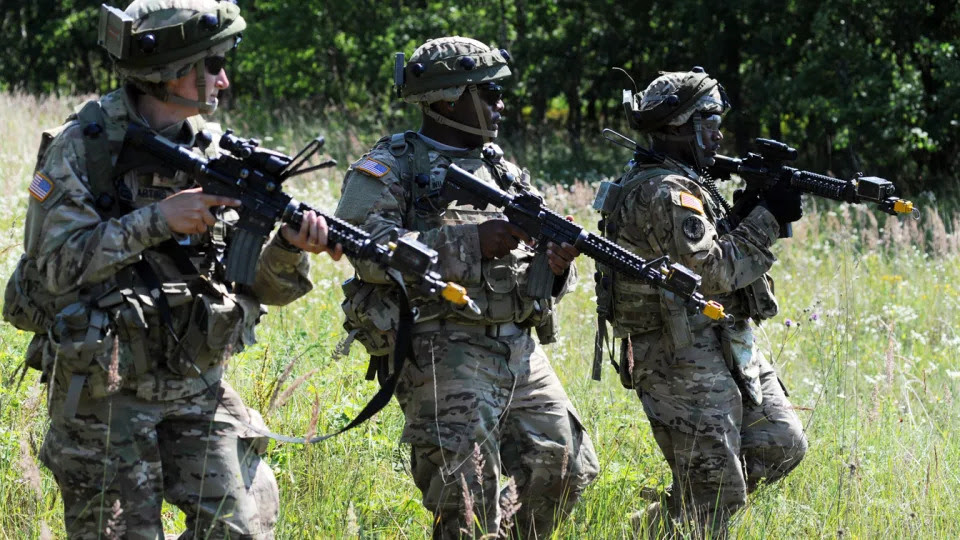 U.S. service members, in camouflage and carrying guns, take part in a drill in Ukraine.