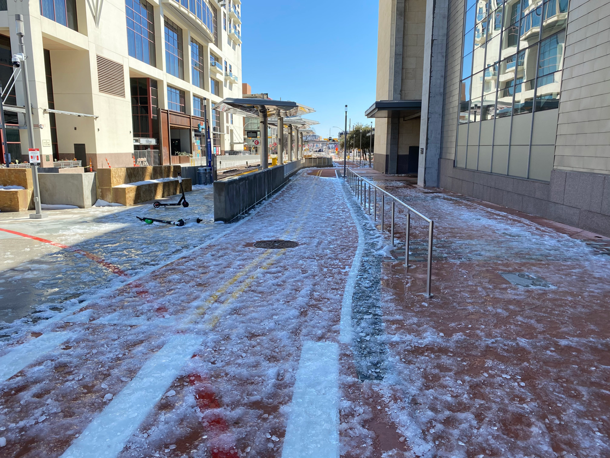 Photo of the Downtown Station, showing the bikeway as itintersects with a crosswalk, plus lots of ice and snow on the ground