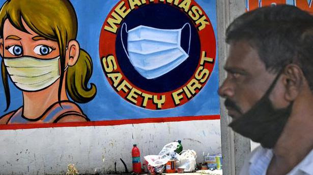 
12/05/2021 : A man with his mask down crosses a wall painting promoting the safety of masks at Dr.M.G.Ramachandran Central Railway station on Wednesday. 