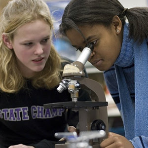 Two students working with
                                          a microscope