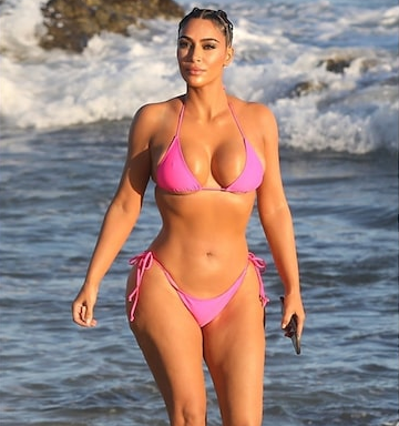 Kim Kardashain displays her curves in a skimpy pink bikini