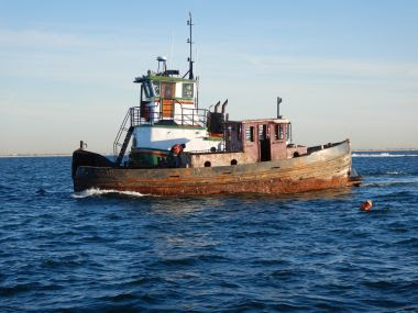 Rusty tugboat floating on the ocean surface