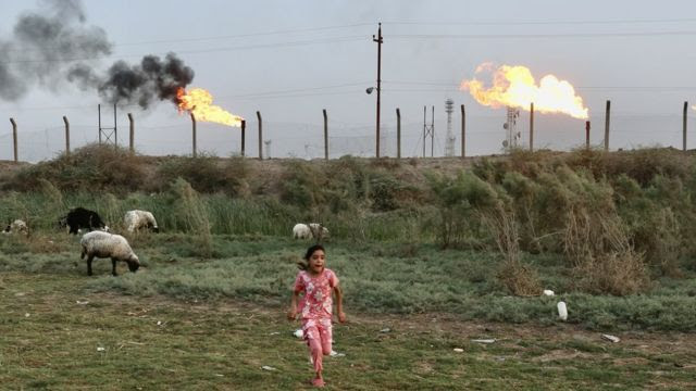 Garota correndo em frente às chamas em Nahran Omar