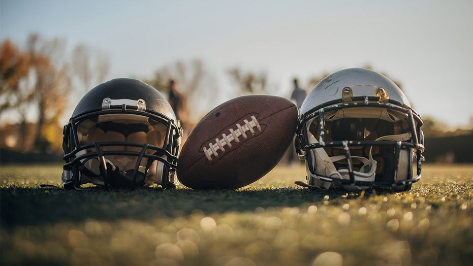 Football between two helmets