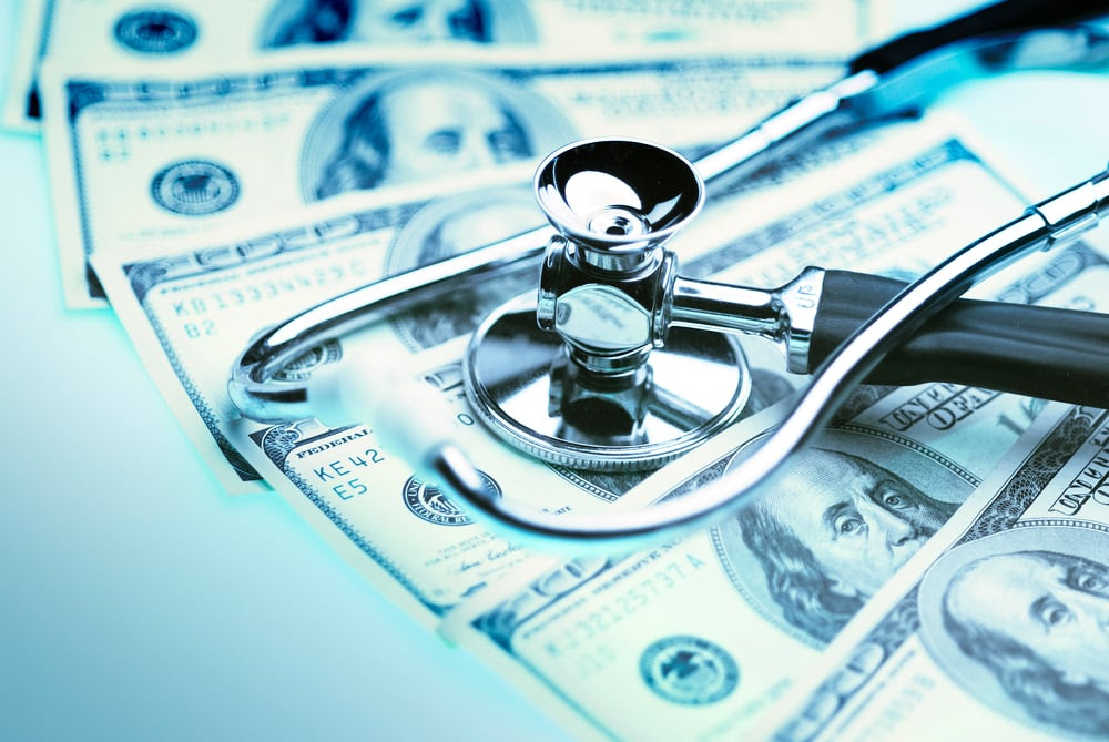 Stethoscope on top of money Stethoscope on top of money