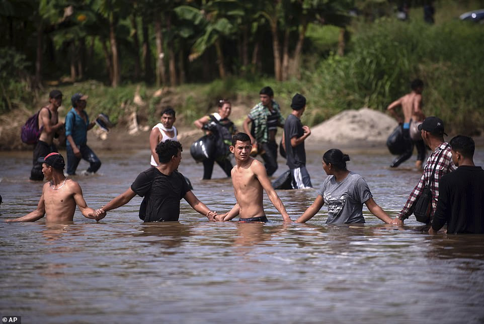 A new group of Central American migrants bound for the US border, wade in mass across the Suchiate River that connects Guatemala and Mexico Monday