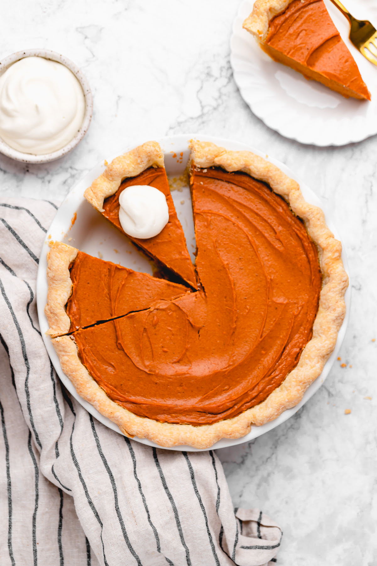 This Vegan Sweet Potato Pie is just like the Southern classic, but made without the dairy and eggs. Sweet, creamy, and perfect! Overhead view of vegan sweet potato pie in pan with 2 slices cut
