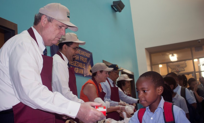 Secretary of Agriculture Tom Vilsack serves breakfast to students. USDA Photo by Laura Crowell