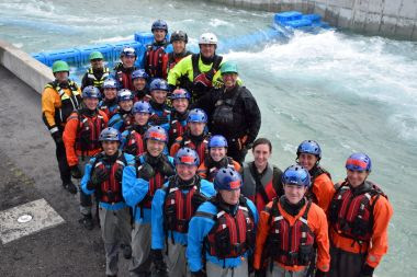 Ranger recruits take a group photo in front of rushing water training area