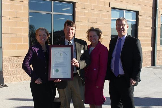 School Construction Director Del McOmie holds a proclamation from Governor Matt Mead recognizing the opening of Pine Bluffs Elementary School alongside State Superintendent Jillian Balow, the school's principal, and the district superintendent.