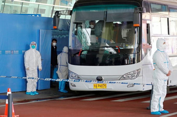 Xe chở nhóm chuyên gia WHO đến điều tra nguồn gốc Covid-19 rời sân bay tại Vũ Hán hôm 14/1. Ảnh: Reuters.